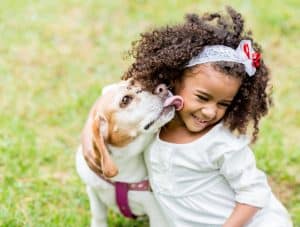 dog kissing smiling girl