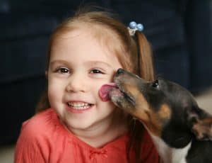 girl smiling dog kiss
