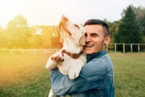 young man holding dog
