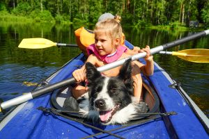 girl with dog in boat