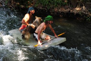 men and dog on raft